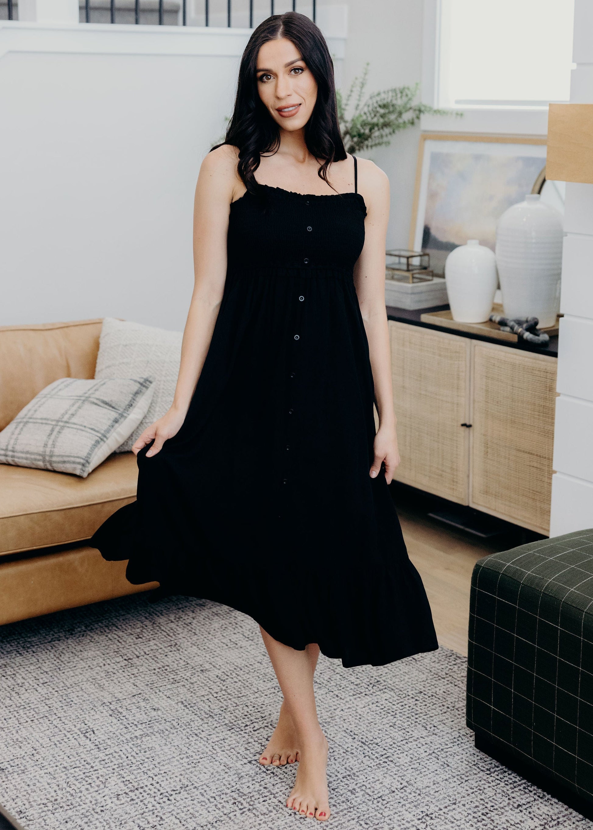 Black fit and flare dress tank dress with ruffle hem, smocked bodice, and button detail.