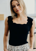 Black sweater tank with scallop edging on neckline and shoulders.